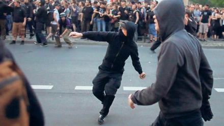 Demonstranten werfen in Berlin im Stadtteil Kreuzberg bei der "Revolutionären 1. Mai-Demonstration" mit Steinen.