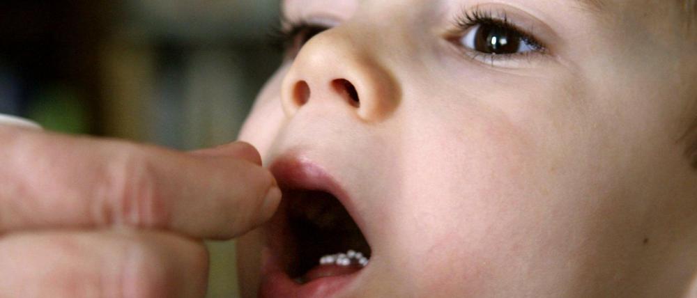 Glaubenssache Globuli: Ein kleiner Junge bekommt homöopathische Zuckerkügelchen verabreicht.