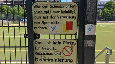 Schilder an Berliner Fußballplatz, die zu Gewaltlosigkeit und Respekt aufrufen.