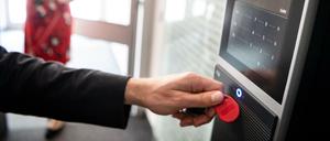 Ein Mitarbeiter erfasst seine Arbeitszeit digital an einem Terminal. 