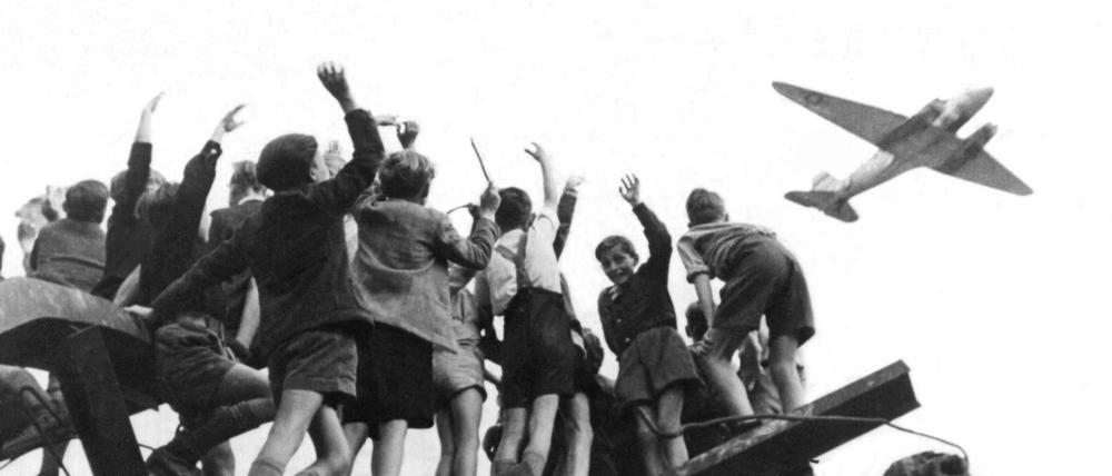 West-Berliner Jungen begrüßen winkend ein US-amerikanisches Transportflugzeug (Archivbild von 1948). 
