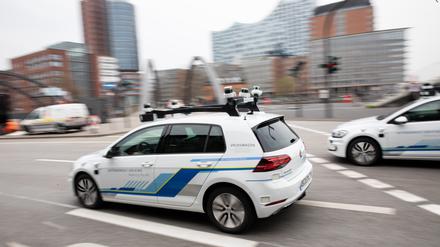 ARCHIV - 03.04.2019, Hamburg: Zwei Elektro-Golf von Volkswagen, bestückt mit Laserscannern, Kameras, Ultraschallsensoren und Radar für vollautomatisches Fahren, sind bei einem Fototermin vor einer Pressekonferenz unterwegs. Der VW-Konzern stellte am Mittwoch in Hamburg seine erste Teststrecke für autonomes Fahren in einer deutschen Großstadt vor. Ab sofort sollen fünf Elektro-Golf autonom in der Hansestadt unterwegs sein. (zu dpa "Jahresrückblick Hamburg und Schleswig-Holstein") Foto: Christian Charisius/dpa +++ dpa-Bildfunk +++ | Verwendung weltweit