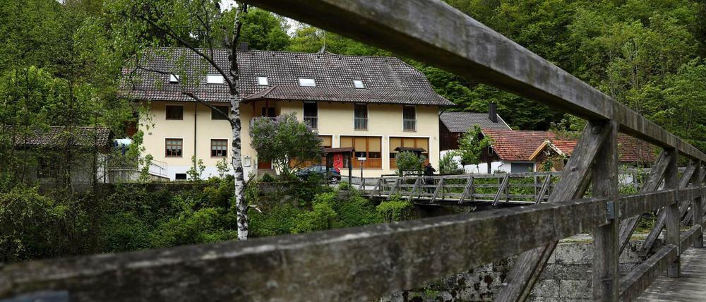Blick durch das Geländer einer Brücke über die Ilz auf die Pension in Passau, in der drei Leichen gefunden wurden. 