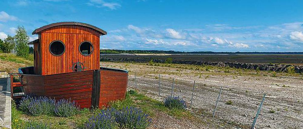 Auf dem Trockenen. In Vorfreude auf den Ostsee wurde schon mal ein kleines Holzschiff aufgestellt. Foto: Patrick Pleul/dpa
