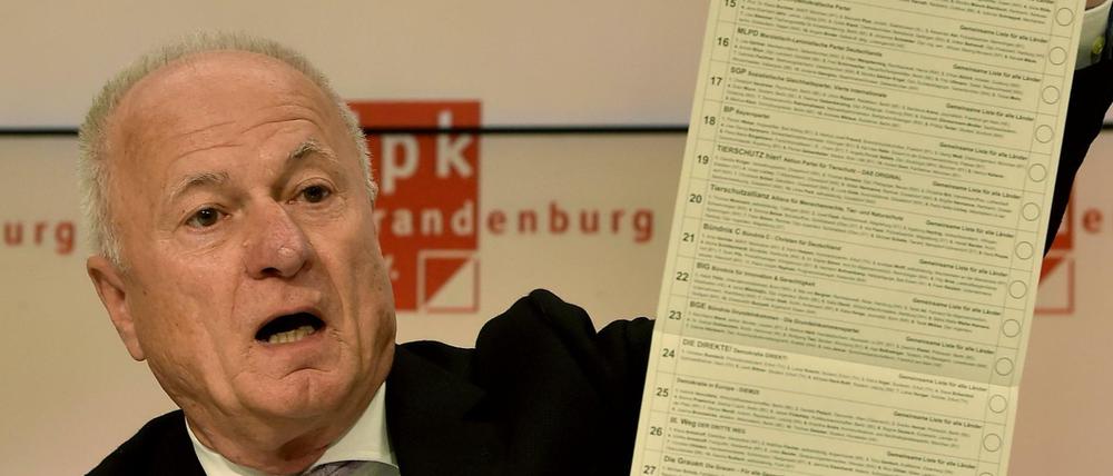 Brandenburgs Landeswahlleiter Bruno Küpper mit einem Stimmzettel für die Europawahl. Hinzu kommen jene für die Kommunalwahl.