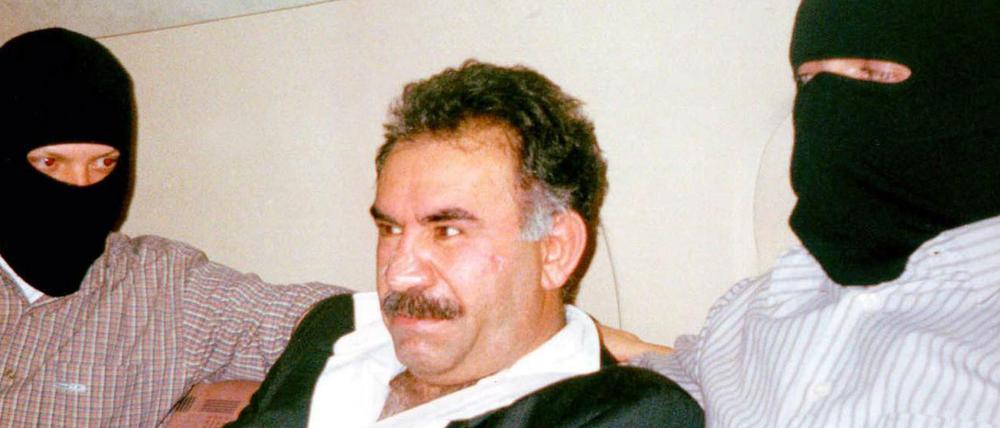 PKK-Führer Abdullah Öcalan gefesselt in einem Flugzeug mit türkischen Sicherheitskräften auf dem Weg in die Türkei.