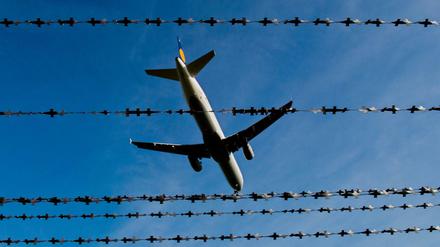 Ein Flugzeug fliegt am Flughafen in Hannover hinter Stacheldraht (Symbolbild). 
