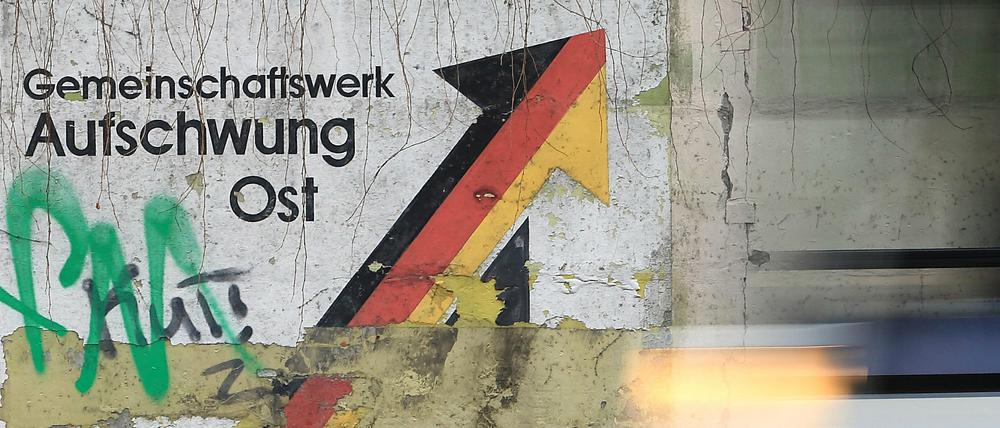 "Gemeinschaftswerk Aufschwung Ost" steht an einer Mauer in Magdeburg.
