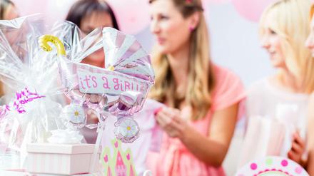 Es wird ein Mädchen. Deko in Rosa, Sahnetorte und Luftballons gehören zu einer Babyshower-Party dazu.