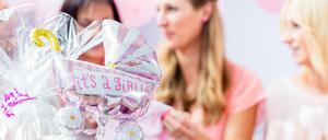 Es wird ein Mädchen. Deko in Rosa, Sahnetorte und Luftballons gehören zu einer Babyshower-Party dazu.