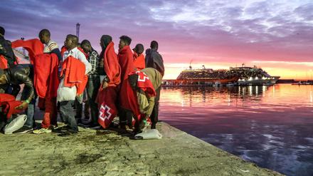 Einwanderer aus Nordafrika stehen am Hafen von Malaga. 