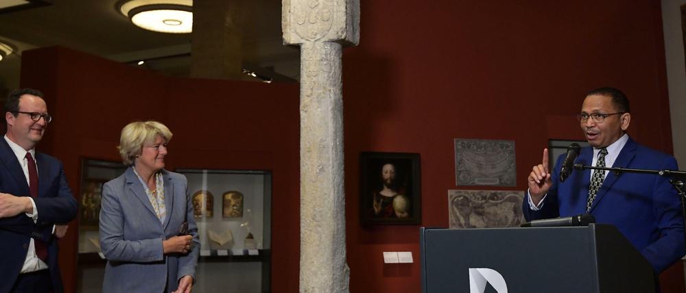 DHM-Direktor Rapahel Gross, Kulturstaatsministerin Monika Grütters und Botschafter Andreas Guibeb (rechts) verkünden die Rückgabe der Kreuzsäule.