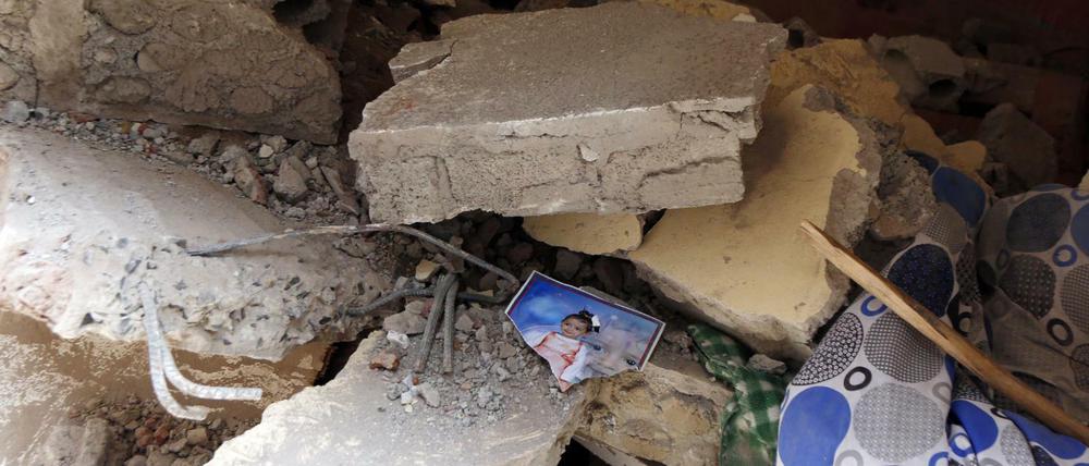 Ein Foto eines Kindes liegt in den Trümmern eines Hauses in Sanaa, das bei Luftangriffen zerstört wurde.