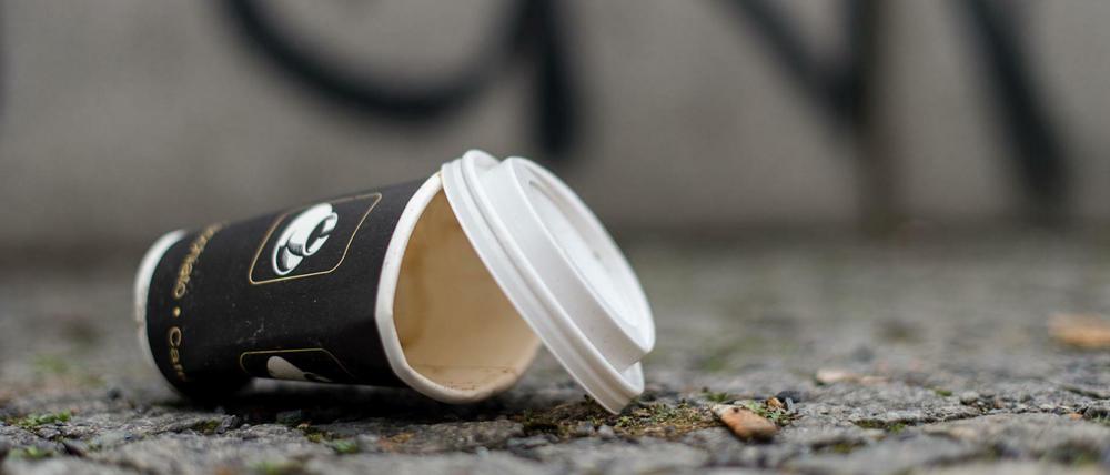 Ein Einweg-Kaffeebecher liegt auf dem Boden. Achtlos weggeworfener Müll ist in vielen Berliner Bezirken ein Problem.