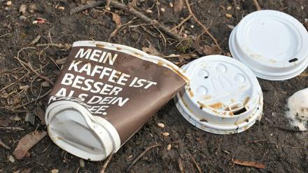 Weggeworfene Einweg-Kaffeebecher im Gras.