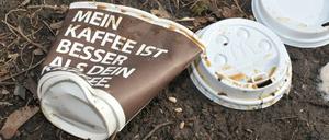 Weggeworfene Einweg-Kaffeebecher im Gras.