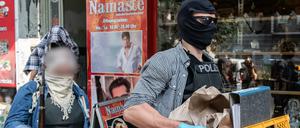 Beamte der Polizei bringen sichergestellte Gegenstände nach einer Clan-Razzia zu ihrem Auto.
