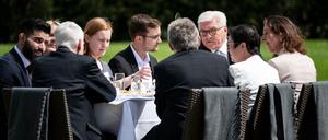 Bundespräsident Frank-Walter Steinmeier (3.v.r) unterhält sich bei der Geburtstagskaffeetafel zum 70. Jahrestag des Grundgesetzes im Park von Schloss Bellevue mit Gästen.