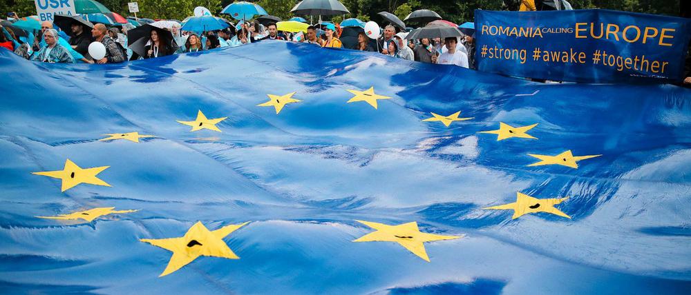 Rumänen halten eine große EU-Flagge bei einer Wahlkundgebung.