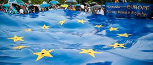 Rumänen halten eine große EU-Flagge bei einer Wahlkundgebung.