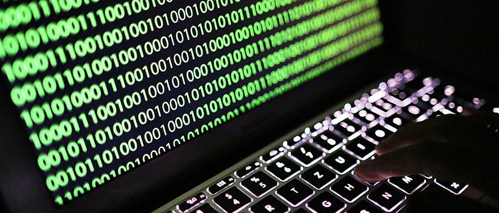 Auf dem Bildschirm eines Laptops ist der Binärcode zu sehen.