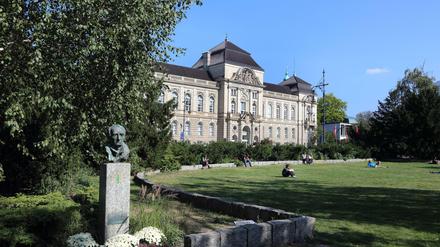 Studierende sitzen auf einer Rasenfläche der Universität der Künste in Berlin.