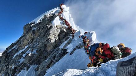 Bergsteiger stehen Schlange, um den Gipfel des Mount Everest zu erreichen.