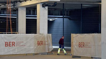 Ein Bauarbeiter geht in die Baustelle im Terminal des BER Flughafens Willy Brandt.