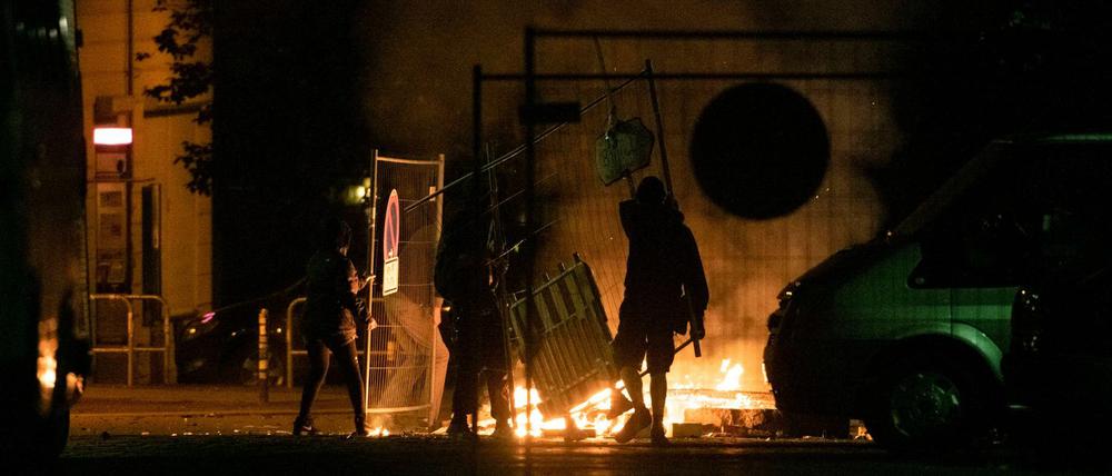 Das geschah in der Nacht zu Sonnabend in der Rigaer Straße: Unbekannte werfen Baumaterialien auf eine brennende Barrikade.
