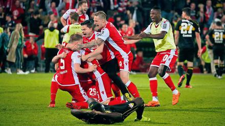 Feierbiester sind sie auch. Unions Spieler bildeten nach dem Abpfiff eine Jubeltraube – und feierten anschließend bis tief in die Nacht ihren Aufstieg in die Bundesliga. Fotos: Sportfoto Rudel, Jan Hübner/Imago (2)