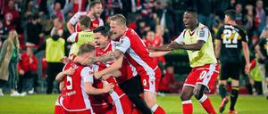 Feierbiester sind sie auch. Unions Spieler bildeten nach dem Abpfiff eine Jubeltraube – und feierten anschließend bis tief in die Nacht ihren Aufstieg in die Bundesliga. Fotos: Sportfoto Rudel, Jan Hübner/Imago (2)
