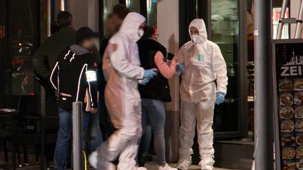 Forensiker der Polizei untersuchen einen Ort vor einem Schnellrestaurant in Frankfurt.