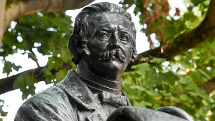 Brandenburg, Neuruppin: Als rastender Wanderer mit Stock und Hut wird der Dichter Theodor Fontane als Denkmal im Stadtzentrum dargestellt.