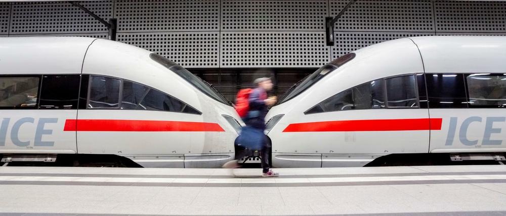 Ein Mann geht im Berliner Hauptbahnhof an einem ICE vorbei.