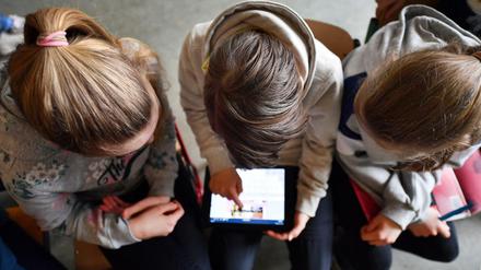 Schüler arbeiten mit einem Tablet.