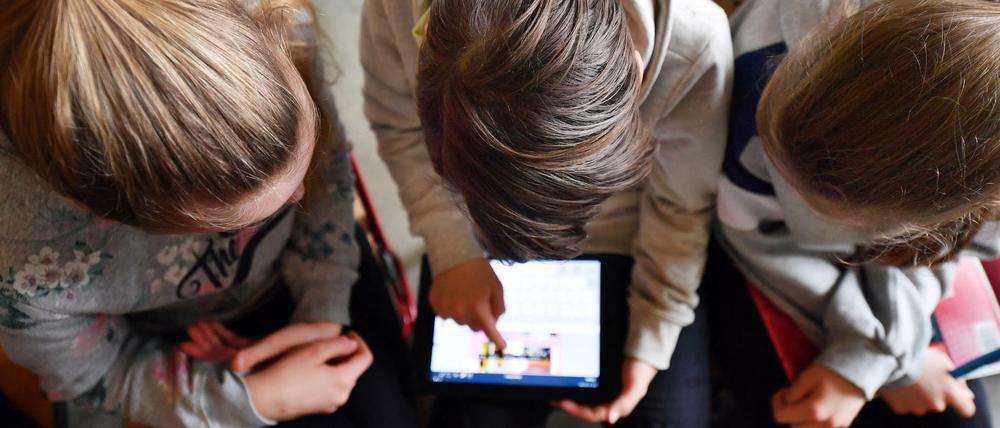 Schüler arbeiten mit einem Tablet.