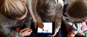 Schüler arbeiten mit einem Tablet.