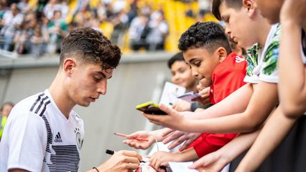 Namen auf den Schuh bitte. Kai Havertz schreibt nach der öffentlichen Trainingseinheit in Aachen Autogramme. 