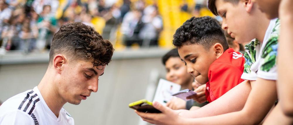 Namen auf den Schuh bitte. Kai Havertz schreibt nach der öffentlichen Trainingseinheit in Aachen Autogramme. 
