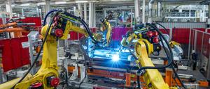 Ob die Beschäftigungsgarantie bis 2029 auch für Kollege Roboter gilt? Schweißroboter am Unterbau eines neuen Volkswagens.