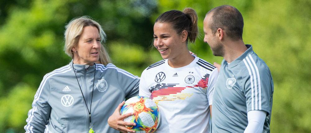 Jetzt geht's los: Bundestrainerin Martina Voss-Tecklenburg und ihr Assistent Patrik Grolimund begrüßen Lena Oberdorf auf dem Rasen.