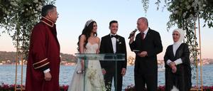 Recep Tayyip Erdogan (2.v.r), Präsident der Türkei, spricht auf der Hochzeit von Fußballer Mesut Özil (M) und seiner Ehefrau, der Schauspielerin Amine Gülse (2.v.l). Im Hintergrund stehen Erdogans Ehefrau Emine (r) sowie Ali Yerlikaya (l), vorübergehender Bürgermeister von Istanbul.