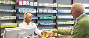Geschenke verboten: Apothekerin berät einen Kunden, der ein Medikament auf Rezept abholt.