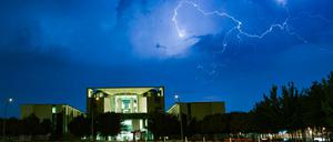 Blitze zucken während eines Gewitters über dem Bundeskanzleramt über den Himmel.