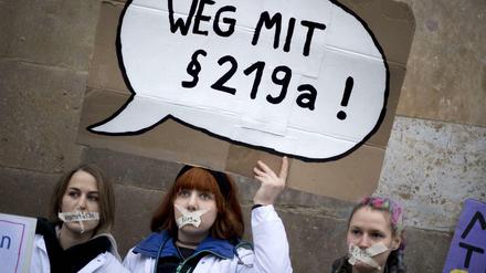 Demonstranten fordern bei einer Kundgebung, dass Paragraf 219a abgeschafft wird.