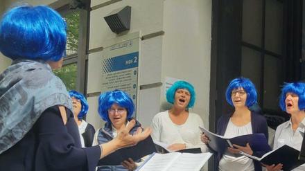 Lesbenchor "Spreediven", singend mit blauen Perücken.