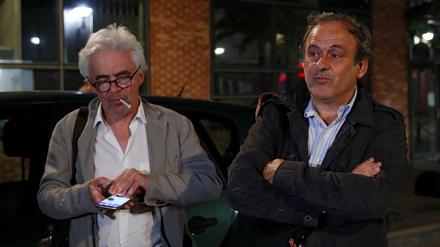 Entlassen, aber entlastet wohl noch nicht. Michel Platini (rechts) und sein Anwalt William Bourdon (mit der Zigarette danach) verlassen die Polizeistation. 