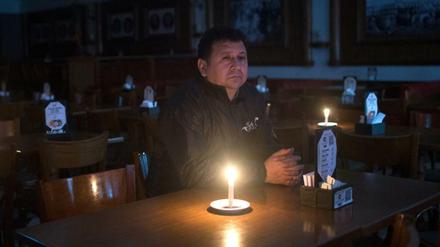 Ein Kunde sitzt in einer Bar an der Avenida de Mayo Buenos Aires während eines Stromausfalls. 
