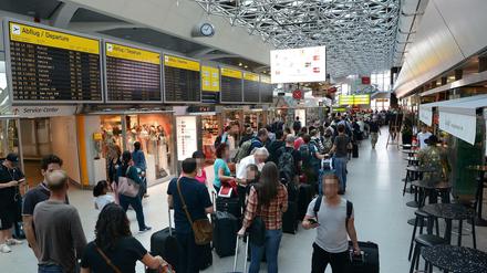 Am Samstagvormittag zieht sich die Schlange am Check-in in Tegel durch das Terminal, Passagiere brauchen Geduld.