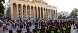 Die Polizei beobachtet Demonstranten, die sich vor dem georgischen Parlamentsgebäude in Tiflis versammeln.